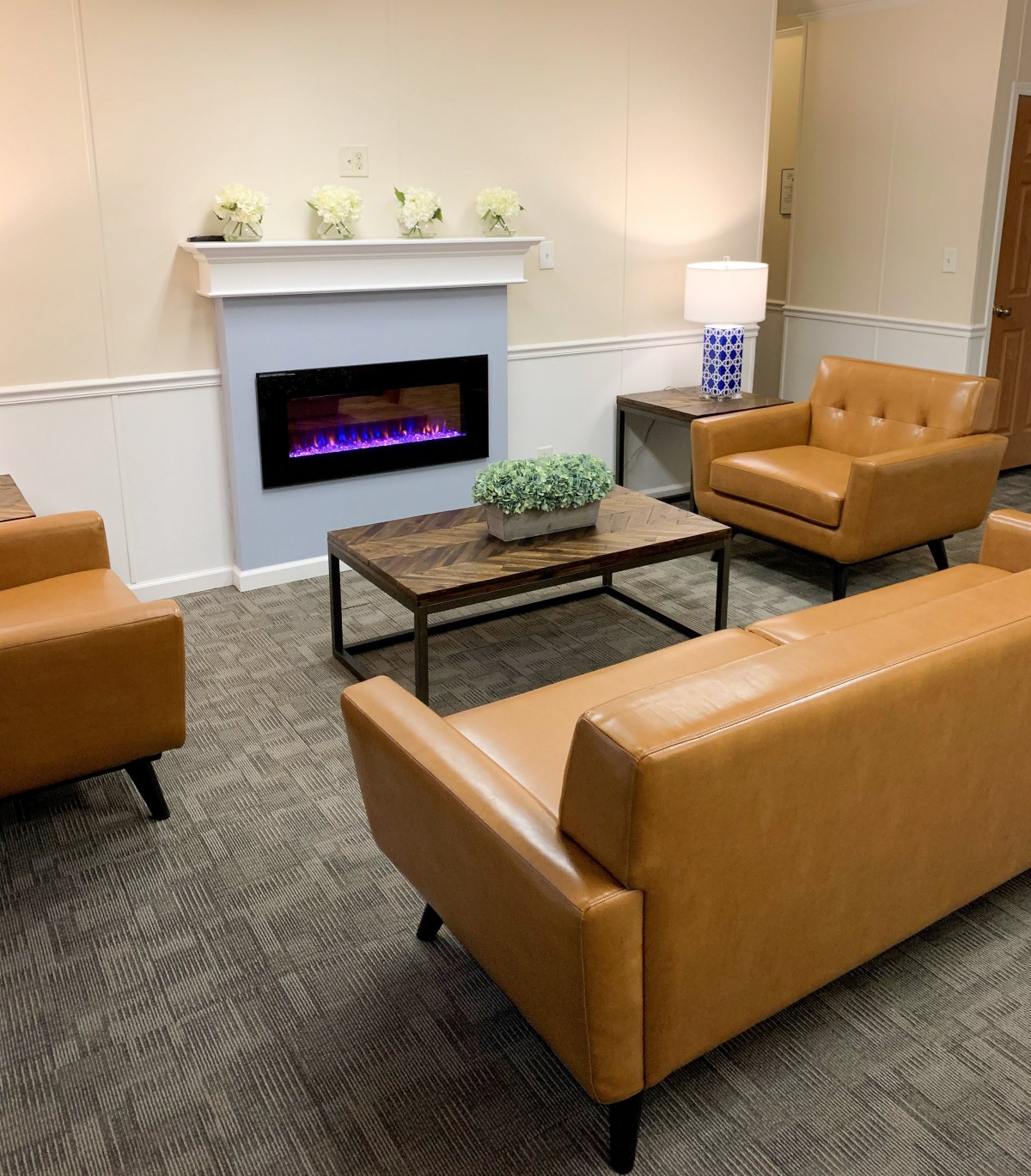A cozy living room with modern furniture and a fireplace.