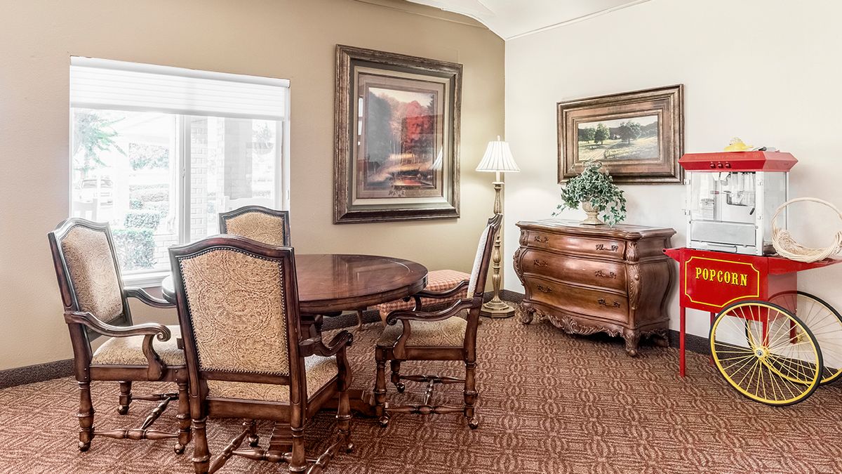 A traditionally styled dining room with elegant wooden furniture and artwork on the walls.