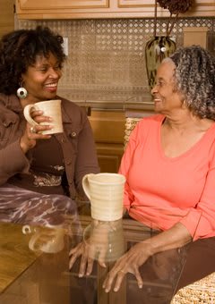 Two women enjoying a casual conversation over coffee indoors.