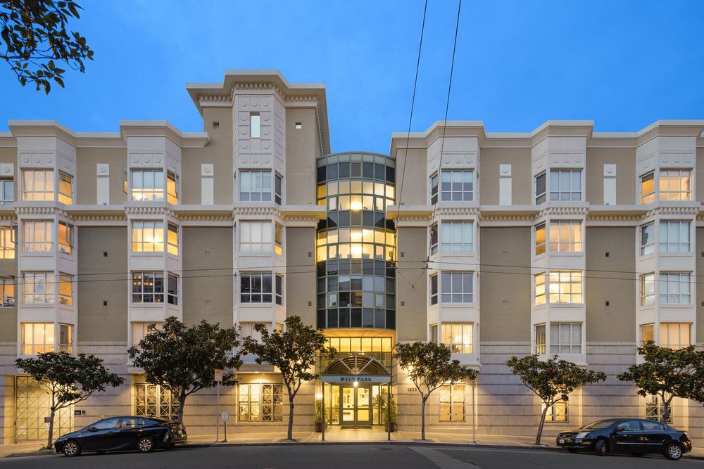 A well-lit residential apartment building at dusk.