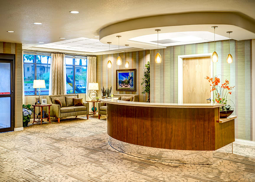 A spacious and elegantly designed hotel lobby with a reception desk and comfortable seating area.