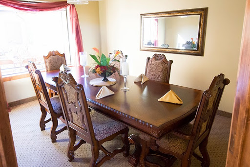 A beautifully arranged dining room featuring a wooden table, elegant chairs, and decorative elements.