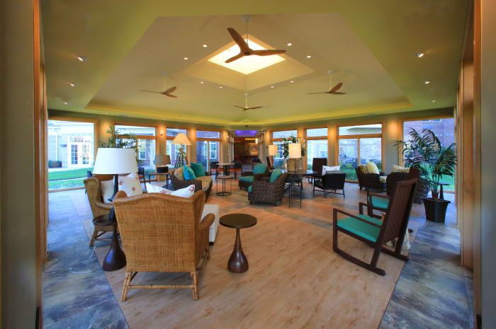 A modern living room with stylish furniture, wooden floors, and large windows.