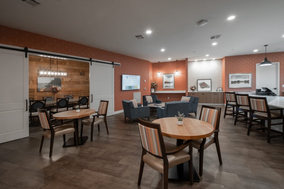A cozy lounge area with seating arrangements, including tables, chairs, and sofas.