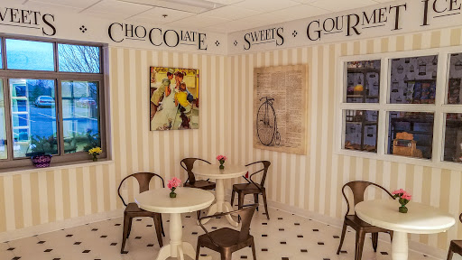 A cozy cafe corner decorated with sweet-themed artwork, perfect for enjoying chocolate treats.