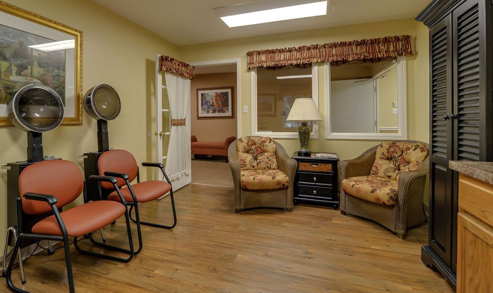 A cozy waiting room with chairs and a lamp.