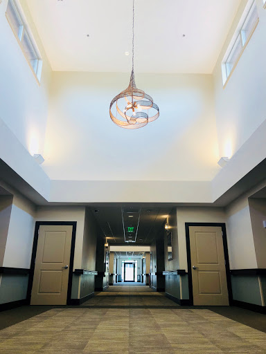 A spacious and elegantly designed hallway featuring a stylish chandelier.
