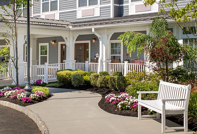 A charming house with a welcoming front porch and beautiful garden landscaping.