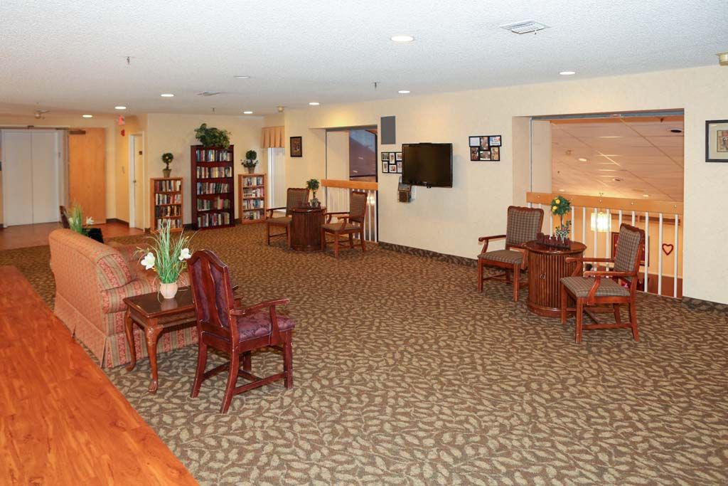 A spacious lounge area with comfortable seating and a television.