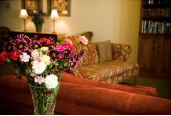 A cozy living room with a floral arrangement in the foreground.