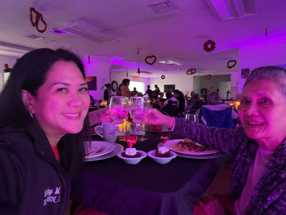 Two people enjoying a meal together in a dimly lit, festive restaurant setting.