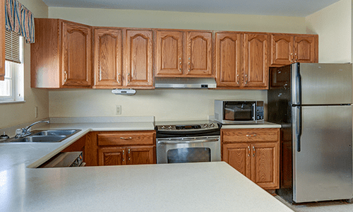 A kitchen with wooden cabinets, a stove, and a countertop.