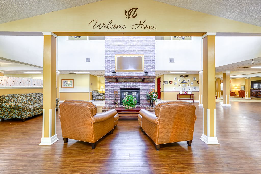 A welcoming lounge area with cozy leather chairs and a central fireplace.