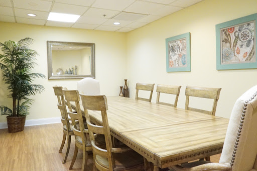 A spacious meeting room featuring a wooden conference table surrounded by chairs, designed for collaborative discussions.