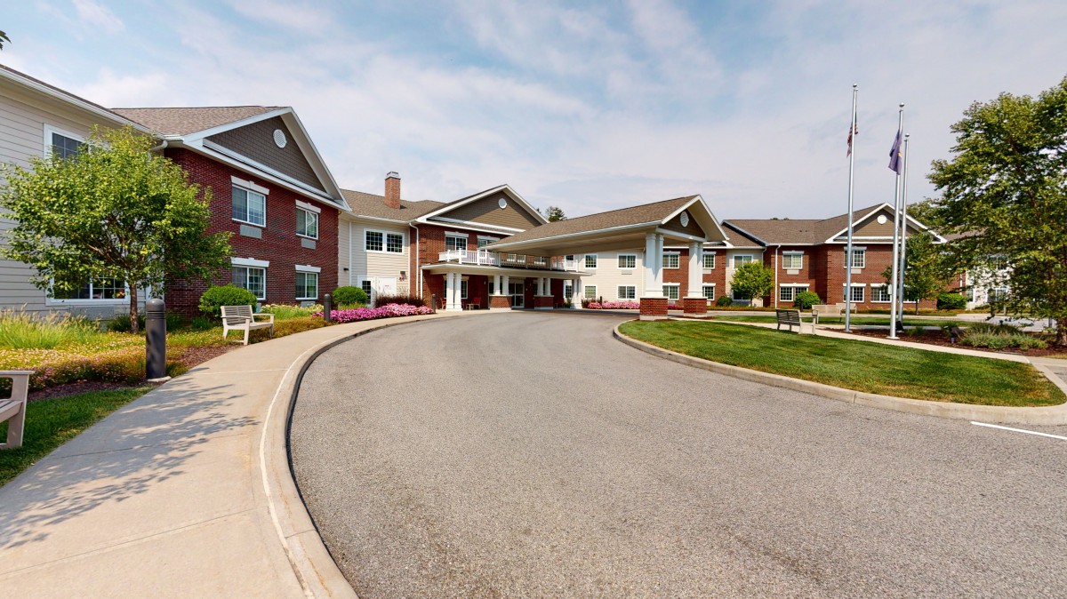 A residential building with a circular driveway and well-maintained landscaping.