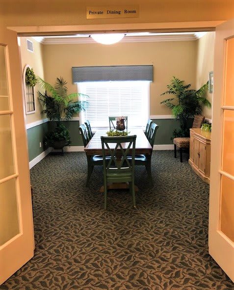 A cozy dining room with a table, chairs, and decorative plants.