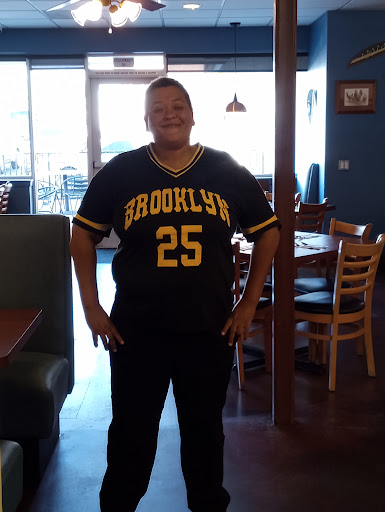 A person wearing a Brooklyn jersey, smiling in a casual setting.