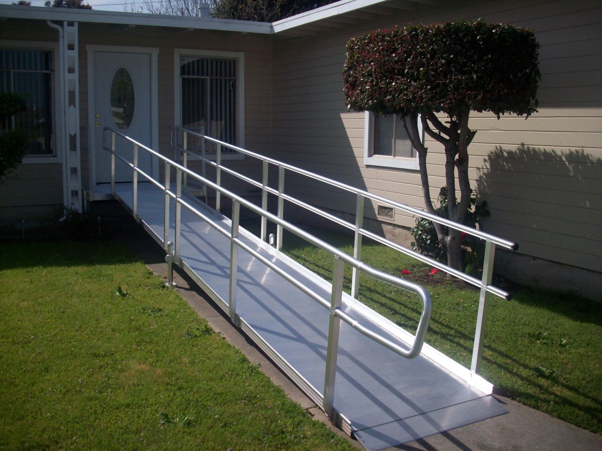 A wheelchair ramp with railings leading to the front door of a house, enhancing accessibility.