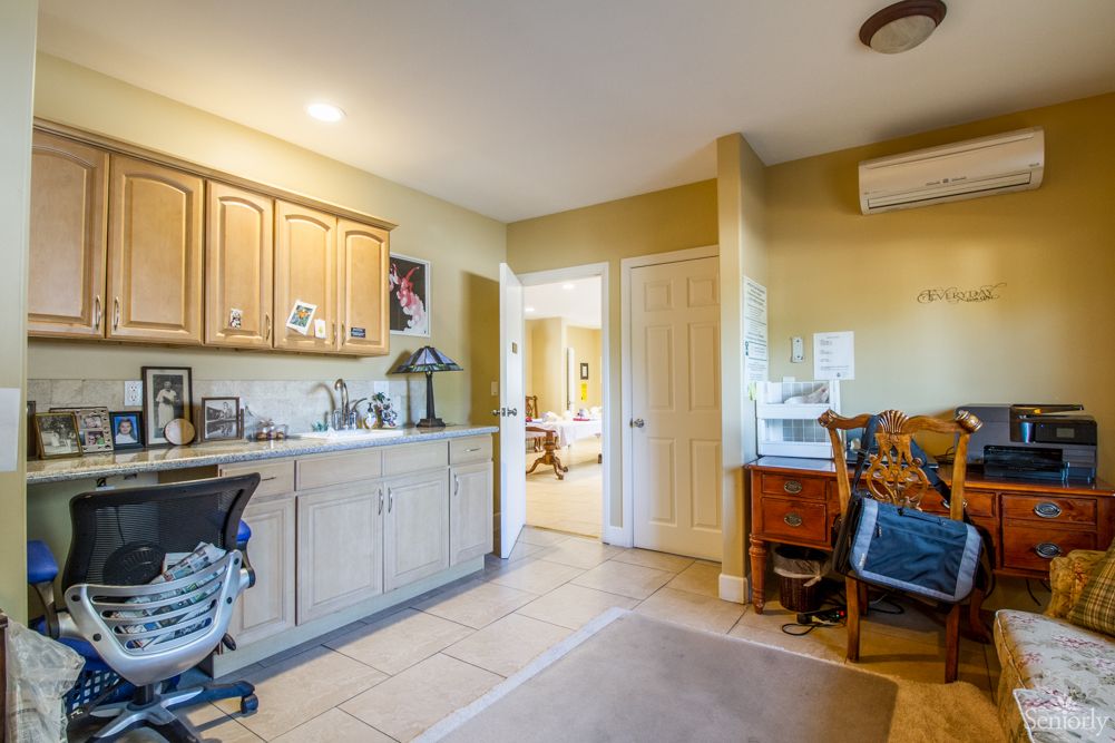 A cozy home office with a desk, chair, and cabinets providing ample workspace.