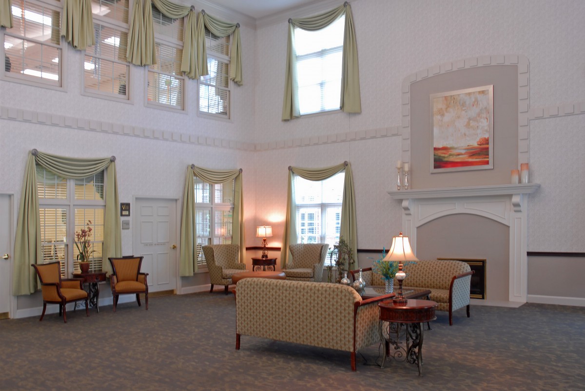A spacious and elegantly decorated lounge area featuring comfortable seating and large windows.