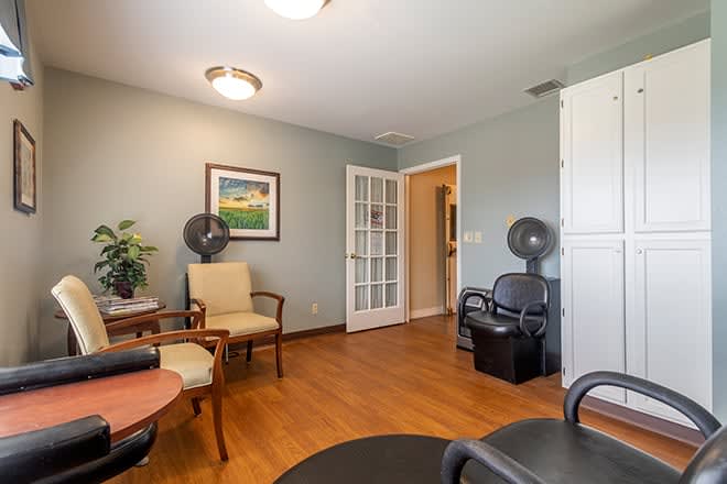 A cozy waiting area in a salon with seating and decor.