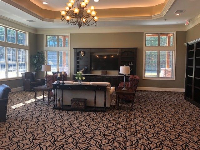 A spacious and elegantly decorated living room with a chandelier.