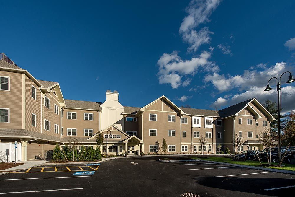 A modern residential building under a clear blue sky with scattered clouds.