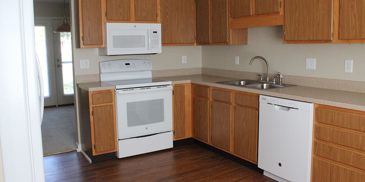 Modern kitchen with wooden cabinets and standard appliances.
