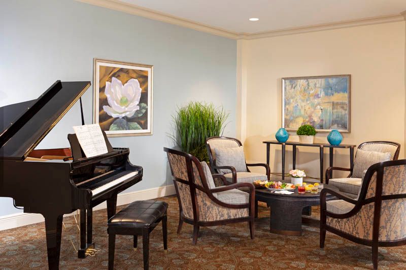 A cozy living room featuring a piano, comfortable seating, and elegant decor.