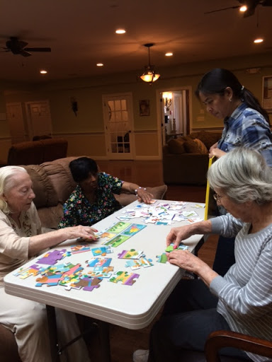 A group of people engaged in a puzzle activity, showcasing collaboration and interaction in a cozy indoor setting.