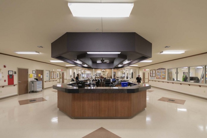 A central nurses station in a hospital with bright fluorescent lighting and medical equipment.