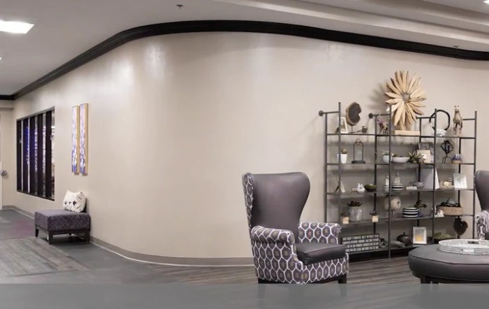 A modern lobby featuring a patterned armchair and decorative shelving.