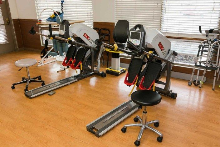A room equipped with specialized fitness machines used for physical therapy and rehabilitation.