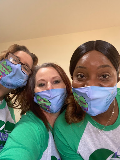 A cheerful group of friends wearing matching masks, enjoying a moment together.