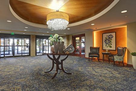 A beautifully designed hotel lobby featuring a chandelier, elegant furniture, and tasteful decor.