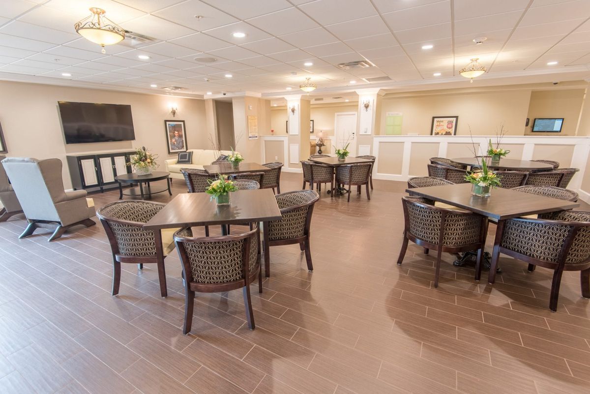 A spacious dining area with multiple tables and chairs, elegantly decorated.