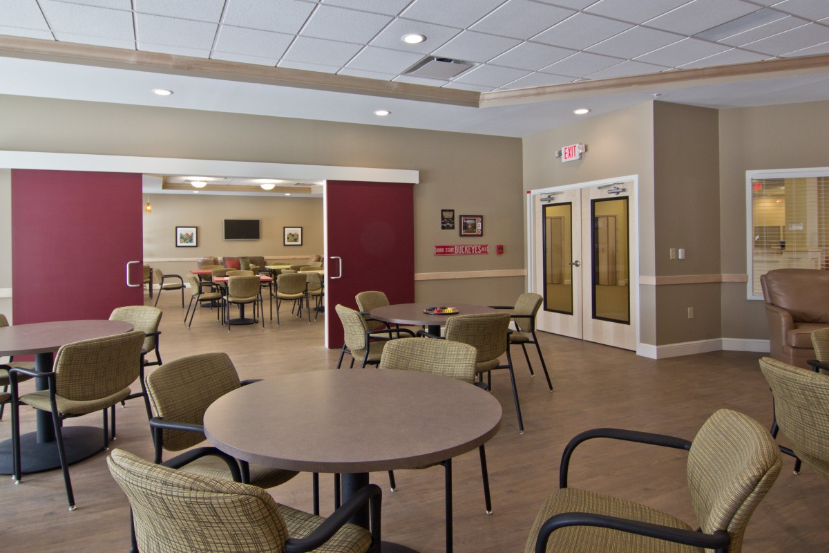 An empty meeting room with several tables and chairs arranged neatly.