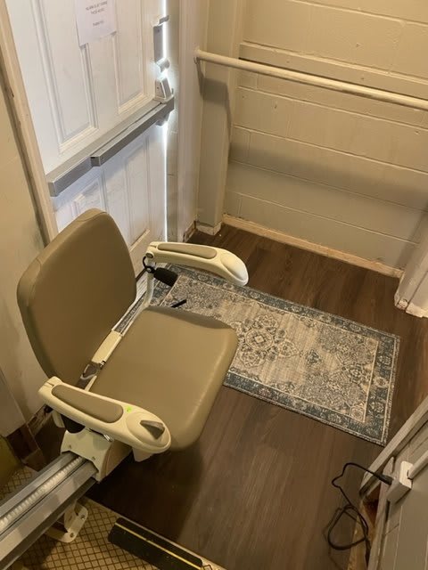 A stairlift chair installed indoors to assist with mobility.