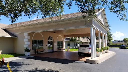 A welcoming entrance to a residential building with a car parked under the portico.