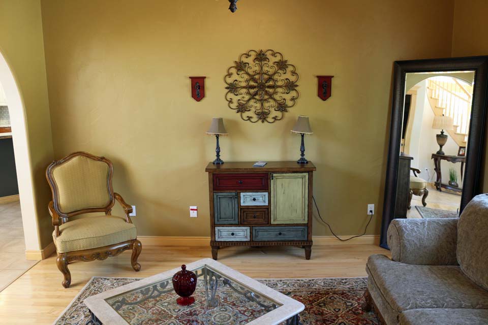 A vintage-style living room with a decorative cabinet and armchair.
