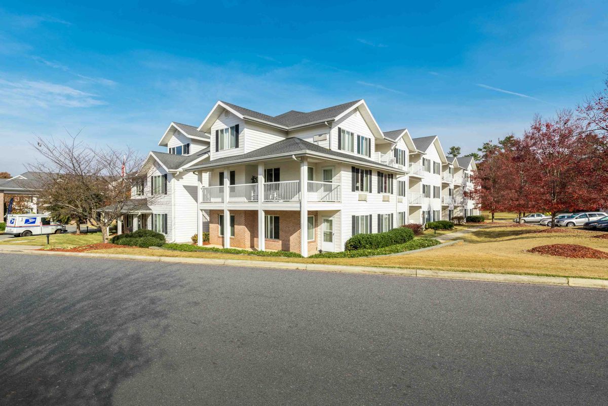 A suburban apartment building with multiple floors and balconies on a clear day.