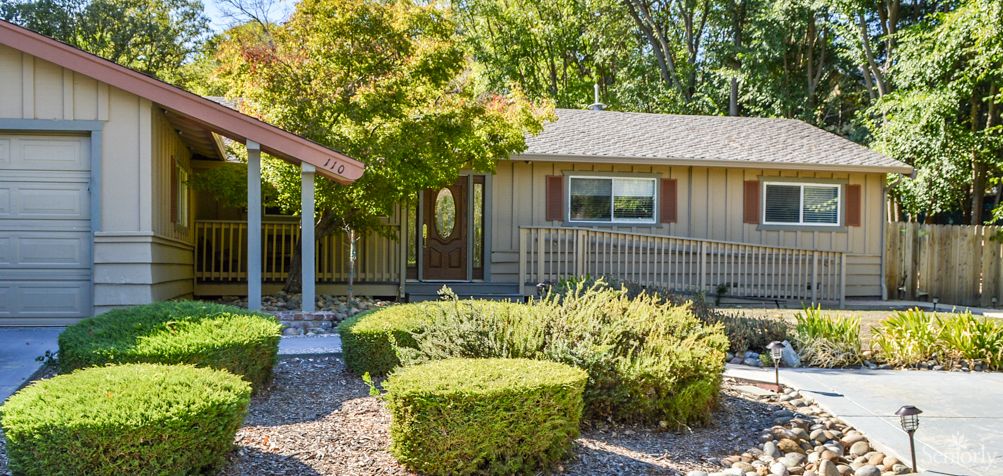 A cozy single-story house with a well-maintained garden and trimmed bushes.