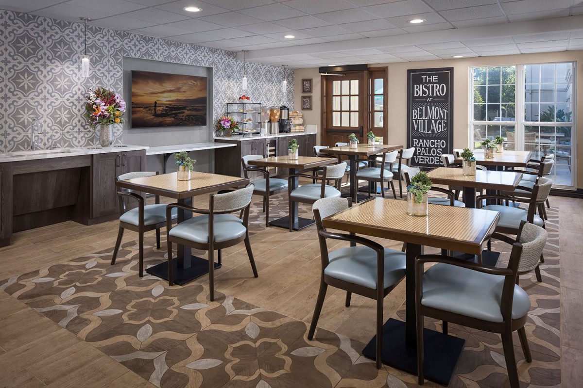 A modern dining area with neatly arranged tables and chairs, featuring stylish decor and artwork on the walls.