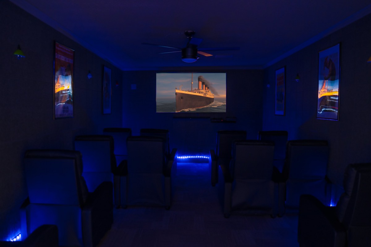 A cozy home theater with a projector screen and comfortable seating, ready for movie night.