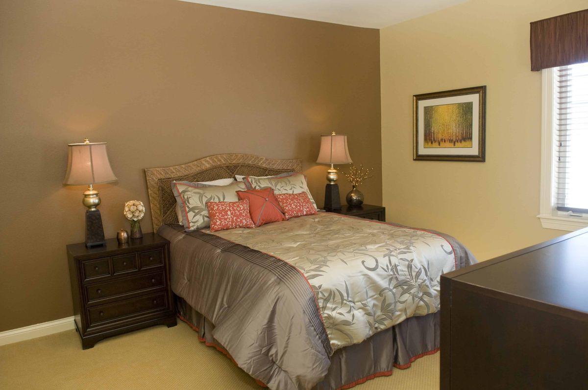A cozy bedroom with warm-toned walls and elegant decor.