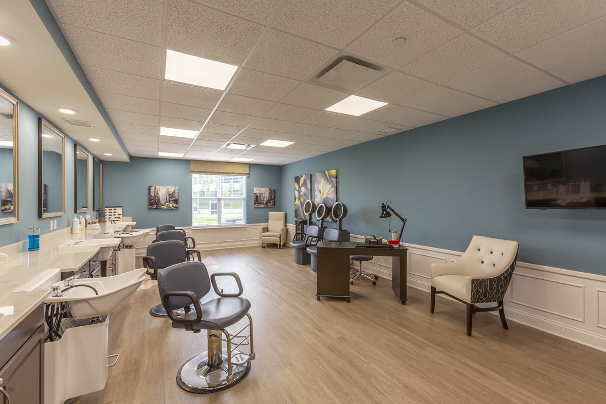A modern hair salon interior with multiple workstations and styling chairs.