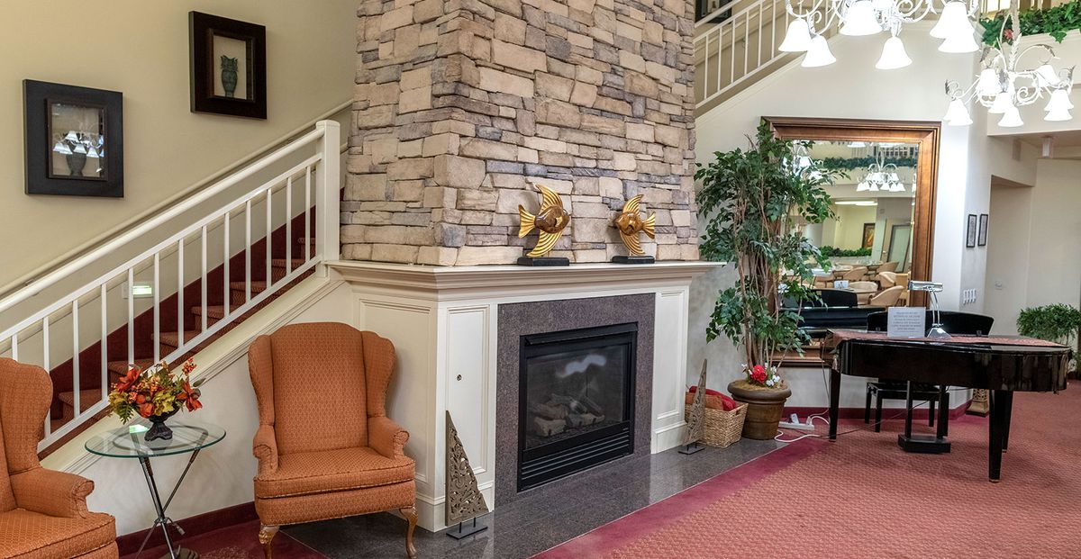 A cozy living room featuring a stone fireplace and comfortable seating.