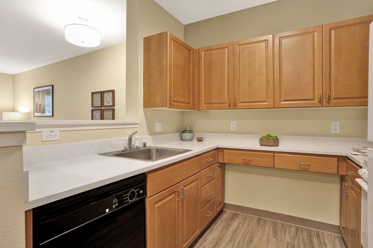 A modern kitchen with wooden cabinets and a clean countertop.