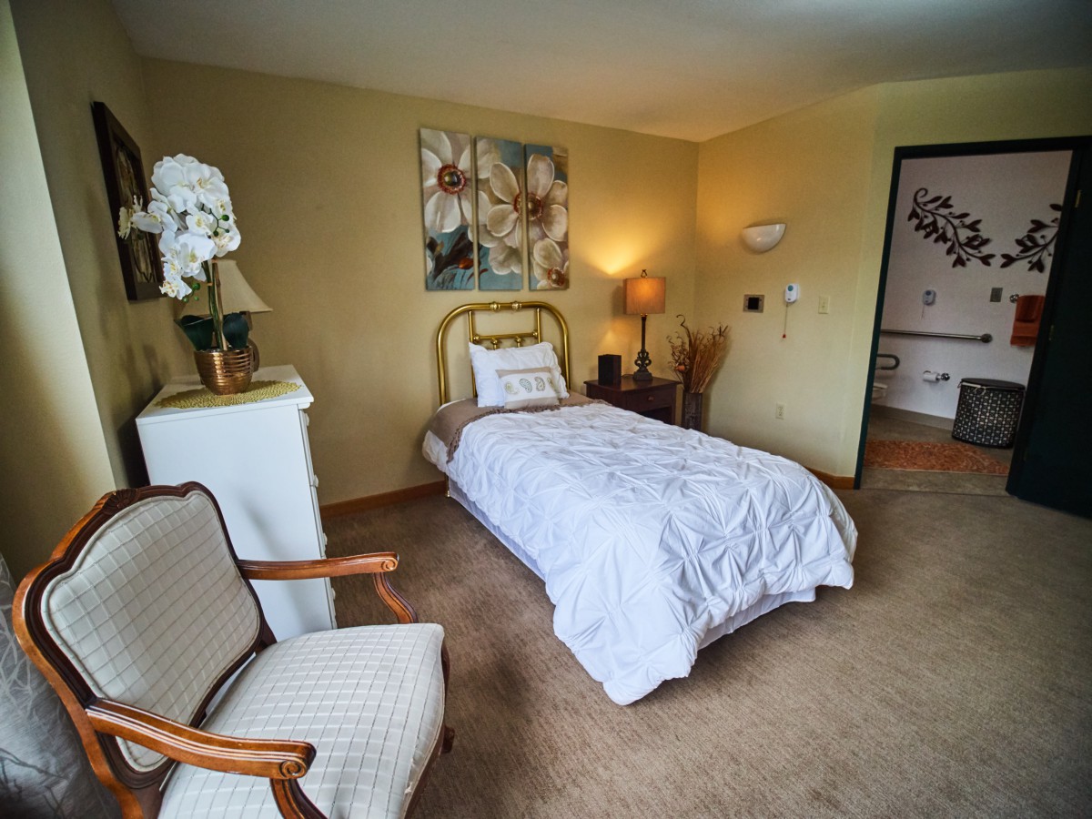 A cozy bedroom with a single bed, elegant decor, and soft lighting.