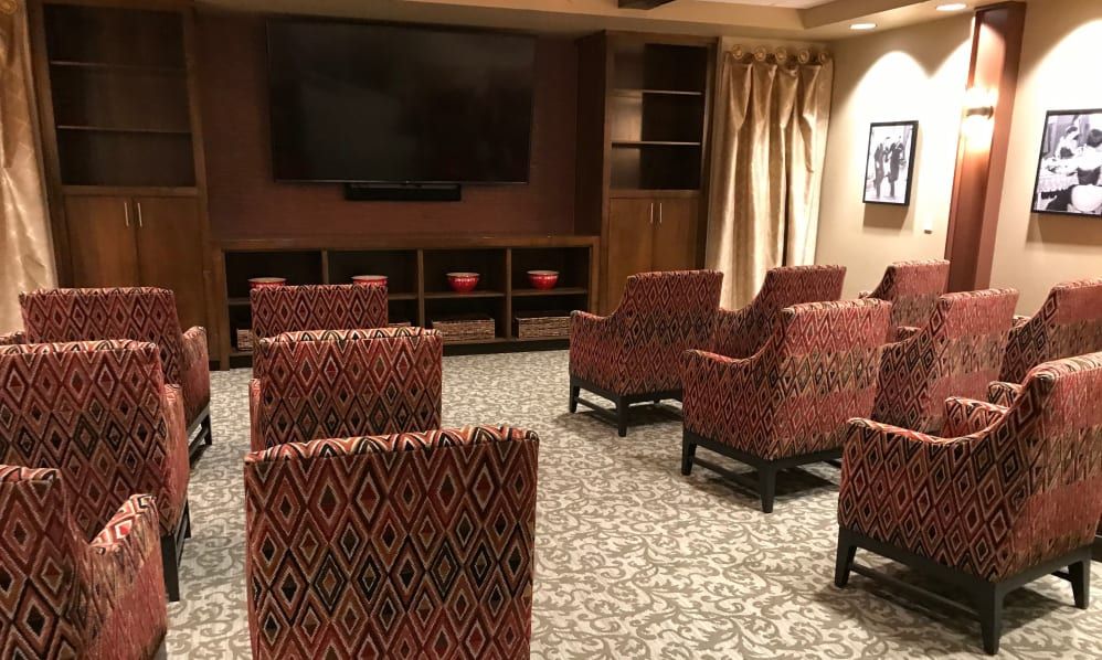 A cozy home theater setup with patterned chairs and a large screen.